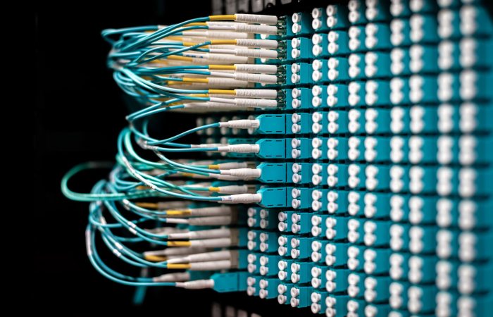 Server with electronic switches and connectors with yellow and green wires plugged in plastic device in operating room on black background
