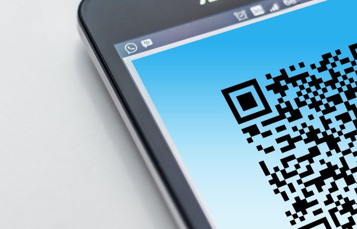 High-resolution close-up of a smartphone displaying a QR code on its screen.
